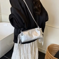 Sac à main argenté métallisé avec plis et franges porté par un mannequin en décor - Argenté