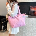 Bolso tote de lona rosa con bolsillo lateral y etiqueta FASHION llevado por una modelo - Rosa