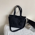 Versatile black nylon tote bag with front pocket and detachable round pouch charm - Black