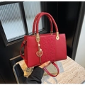 Dettaglio della borsa da sposa rossa con rilievo floreale, manico intrecciato e ciondolo - Rosso