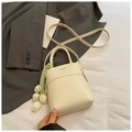 Detail der cremeweißen Beuteltasche aus Leder mit Tulpenanhänger und Schultergurt - Beige Mit Anhänger