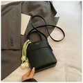 Detail der schwarzen matten Beuteltasche mit weißer Schrift und grünem Tulpenanhänger - Schwarz mit Anhänger
