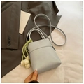 Close-up of a light blue minimalist bucket bag featuring a cute white tulip charm detail - Blue with Charm