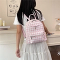 Pink and white checkered backpack with bow and heart charm worn by model - Pink Plaid