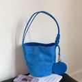 Detail of matte blue bucket bag with knotted straps and a matching round coin purse - Blue