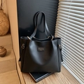 Large black leather tote bag with gold logo and shoulder strap for office commuting - Black