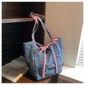 Detailed view of blue denim tote bag featuring red cherry embroidery and checkered bow tie - Light Blue
