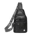 Close-up of black leather crossbody bag featuring geometric patterned wide shoulder strap - Black