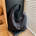 Black polka dot hobo bag with a silver butterfly buckle and textured bow pattern - Black