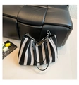 Detalle del bolso tote tejido a rayas blancas y negras con correa de cadena metálica - Negro