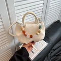 Sac seau plissé crème avec chaîne en perles colorées et bandoulière sur canapé en cuir - Blanc