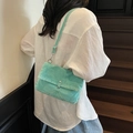 Mint green vintage denim crossbody bag shown on a model on wooden stairs - Green