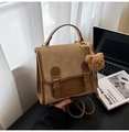 Nahaufnahme brauner Vintage-Wildlederrucksack mit Schnallendetails und Plüschbär - Braun