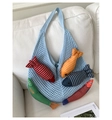 Detail der hellblauen Stricktasche mit bunten Plüschfisch-Anhängern auf einem Sofa - Einheitsgröße / Blau