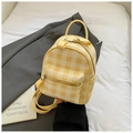 Close-up of yellow and white plaid mini backpack with premium PU texture on white fabric - Yellow