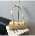 Detail of light yellow baguette bag with glossy wrinkled texture and double zip closure - Yellow