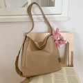 Grand sac hobo en toile kaki avec breloque lapin en peluche rose sur une chaise - Khaki