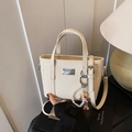 Borsa a secchiello bianco crema con texture in pelle grana, ciondolo perla e logo argento - Stile Bianco (Con Ciondolo)