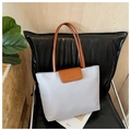 Primer plano del bolso tote gris claro con solapa de cuero marrón y logo grabado - Gris