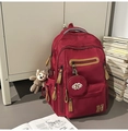 Détail d'un sac à dos bordeaux avec pendentif singe en peluche et porte-monnaie rond - Avec Pendentif / Rouge