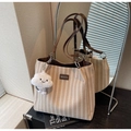 Détail du sac cabas tissé avec étiquette en cuir et accessoire en forme de nuage doux - Kaki