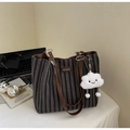 Détail d'un sac cabas en toile à chevrons avec poignées en cuir marron et bijou - Noir
