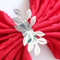 Macro shot of silver metal leaf napkin ring on a premium red textured cloth napkin - Mirror Silver