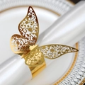 Gros plan d'un rond de serviette papillon doré avec découpes florales complexes - Or Réfléchissant