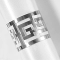Close-up of silver napkin ring with Greek Key hollow design on white satin fabric - Reflective Silver