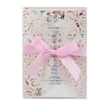 Close-up of laser-cut rose hollow invitation with elegant pink silk ribbon and inner card - Nude Pink