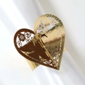 Close-up of golden hollow heart napkin ring with intricate laser-cut floral details - Reflective Gold
