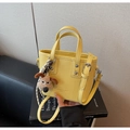 Détail d'un sac bandoulière jaune en cuir grainé avec foulard et charm de chien - Jaune