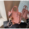Détail du sac seau rose avec charm petit chien et foulard en soie à carreaux chic - Rose