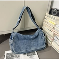 Détail du sac bandoulière en jean avec rabat et poches latérales dans un décor de style de vie - Bleu clair