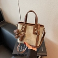 Bolso cubo de lona y cuero marrón con colgante de oso sobre un libro negro - Blanco y Marrón (Con Colgante)