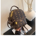 Detalle de mini mochila marrón con estampado de osos, cremallera dorada y colgante - Café con Colgante
