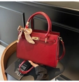 Détail d'un sac à main de mariage en cuir rouge avec ferrures dorées et foulard en soie - Rouge