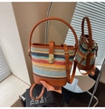 Détail du sac seau tissé à rayures colorées avec lanières en cuir marron et boucle dorée - Fauve