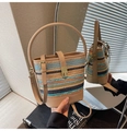Détail d'un sac seau tissé coloré avec bandoulière en cuir beige et boucle métallique - Kaki