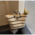 Détail d'un sac cabas en paille tissé avec rayures noires et poignées rondes - Blanc Cassé