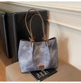 Détail d'un sac fourre-tout en toile délavée avec lanières en cuir et nœuds - Bleu