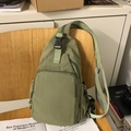 Borsa a tracolla multifunzionale in nylon verde oliva su una sedia in legno - Verde