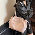 Chic pink PU leather tote bag with bow detail and drawstring shown on a model - Light Pink