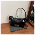 Détail du cabas en cuir verni noir avec fermeture éclair argentée et plaque métallique - Noir