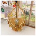Detailaufnahme der gewebten Strohtasche mit bunten Quasten und Stickereiverzierung - Braun