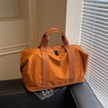 Burnt orange large capacity nylon travel bag with shoe compartment on leather surface - Brown
