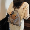 Gray canvas and brown leather tote bag with plush charm shown on a model on stairs - Blackish Green With Pendant