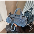 Detailed shot of a blue denim barrel bag with a mini pouch reflected in a mirror - Light Blue