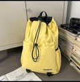 Détail d'un sac à dos en nylon jaune avec cordon de serrage et logo KEMIBAG noir - Jaune