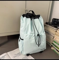 Détail d'un sac à dos en nylon bleu clair avec cordon et accents noirs stylés - Bleu clair